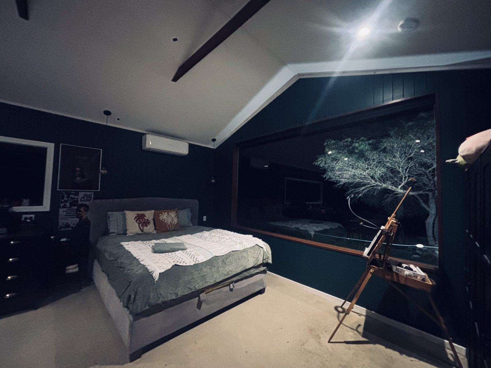 The bed and easel beside the window at night