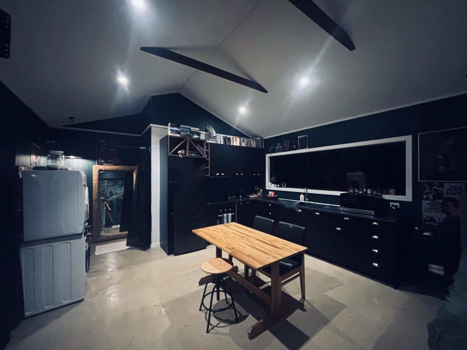 Black kitchen and timber dining table