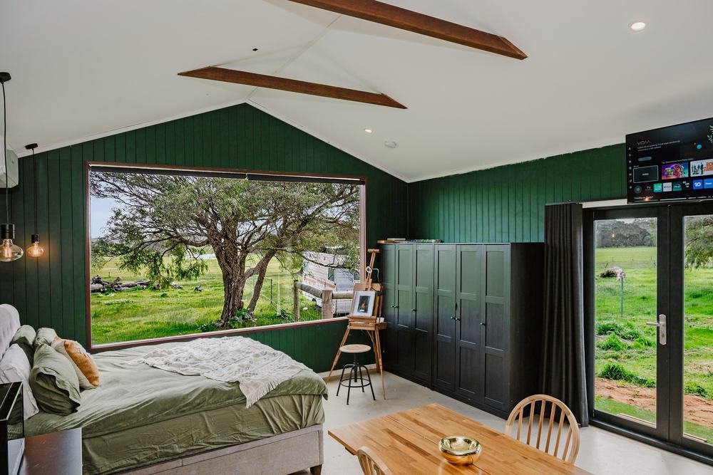The bed, smart TV and the door out to the lawn